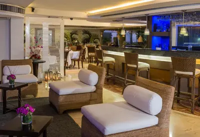 a restaurant with a bar with chairs and a table at Country International Hotel in Barranquilla