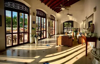 a living room with a ceiling fan and large windows at San Martin Cartagena in Cartagena de Indias
