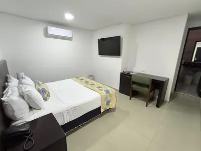 a bedroom with a bed and a desk and a television at San Martin Cartagena in Cartagena de Indias