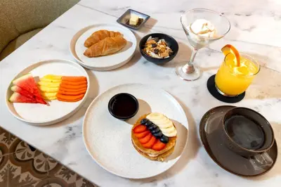a table topped with plates of food and drinks at El Marques Hotel Boutique By GEH Suites in Cartagena de Indias