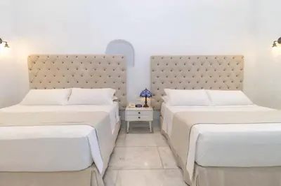 a bedroom with two beds and a large headboard at El Marques Hotel Boutique By GEH Suites in Cartagena de Indias