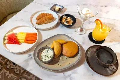 a table topped with plates of food and drinks at El Marques Hotel Boutique By GEH Suites in Cartagena de Indias