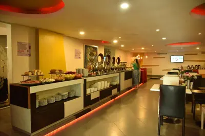 a buffet line in a restaurant with a person in the background at Hotel American Golf in Barranquilla