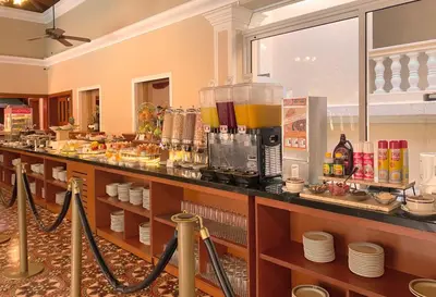 a restaurant with a bar with a counter with food at Hotel El Prado in Barranquilla