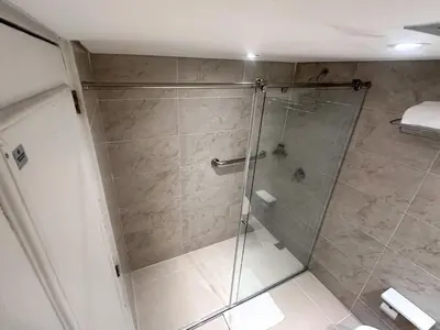 a bathroom with a shower with a glass door at Hotel El Prado in Barranquilla