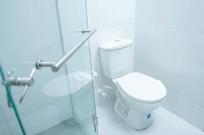 a bathroom with a toilet and a glass shower at Ayenda 1313 Barahona 72 in Barranquilla