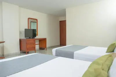 a hotel room with two beds and a television at Ayenda 1313 Barahona 72 in Barranquilla