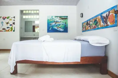 a bedroom with a bed with a white bedspread at Isla Grande Eco-Hostal in Isla Grande