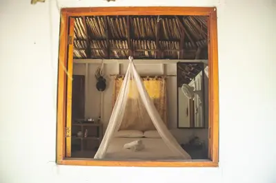 a window with a tent in a room at Isla Grande Eco-Hostal in Isla Grande