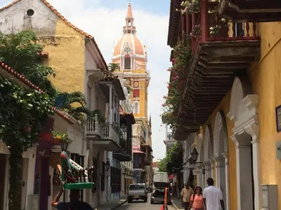 a group of people walking down a street with a clock tower at 41st Fl Beach Condo in Bocagrande in Cartagena de Indias