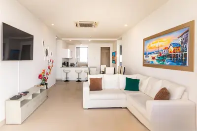 a living room with a white couch and a painting on the wall at 41st Fl Beach Condo in Bocagrande in Cartagena de Indias