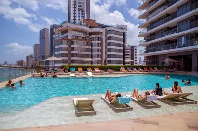 a pool with people laying in chairs in the water at 41st Fl Beach Condo in Bocagrande in Cartagena de Indias