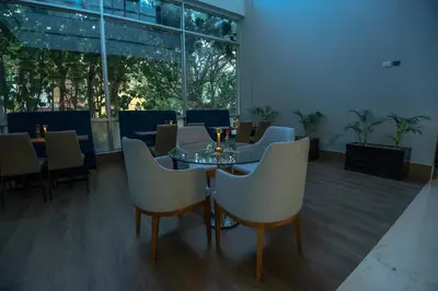 a dining room with tables and chairs and windows at GHL Hotel Barranquilla in Barranquilla
