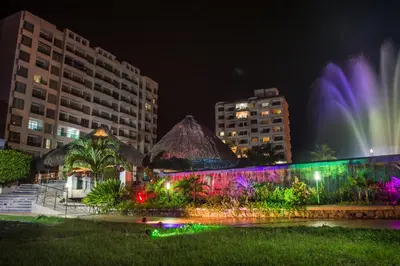 a fountain in the middle of a city at night at GHL Relax Hotel Costa Azul in Santa Marta