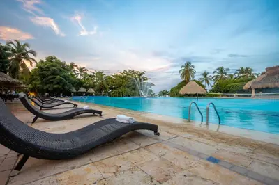 a resort pool with lounge chairs and a swimming pool at GHL Relax Hotel Costa Azul in Santa Marta