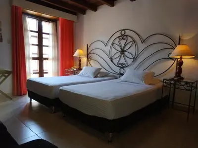 two beds in a bedroom with a large headboard at Casa India Catalina in Cartagena de Indias