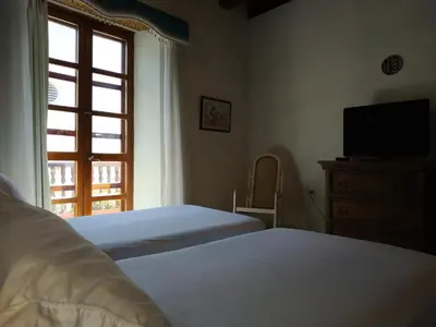 a bedroom with two beds and a television and a window at Casa India Catalina in Cartagena de Indias