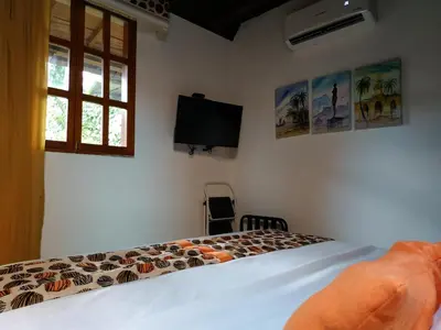 a bedroom with a bed and a flat screen tv at Casa India Catalina in Cartagena de Indias