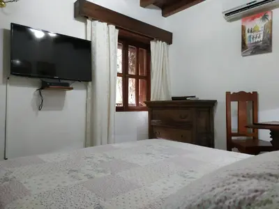 a bedroom with a bed and a flat screen tv at Casa India Catalina in Cartagena de Indias