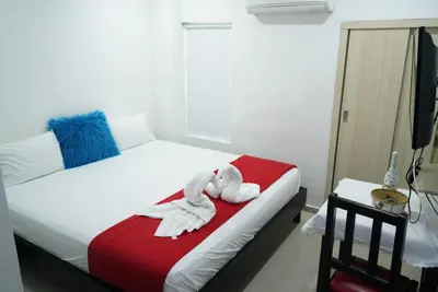 a bedroom with a bed with towels on it at Hotel Sun River in Barranquilla