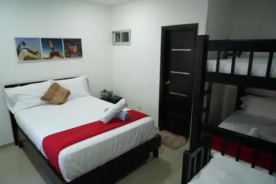 a bedroom with a bed and two bunk beds at Hotel Sun River in Barranquilla