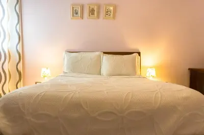 a bedroom with a white bed with two lamps at Hotel Casa La Tablada Manga in Cartagena de Indias