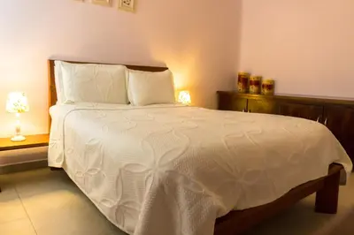 a bedroom with a large white bed with two lamps at Hotel Casa La Tablada Manga in Cartagena de Indias