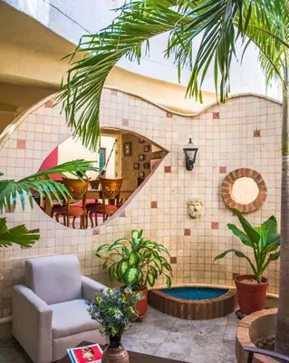 a living room with plants and a staircase at Hotel Casa La Tablada Manga in Cartagena de Indias