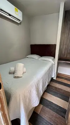 a bedroom with a bed with two pillows on it at Hostel la Antigua Capsula in Cartagena de Indias