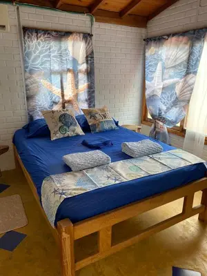 a bed with a blue comforter and pillows on it at El palmar azul in San Bernardo del Viento