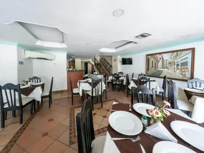 a dining room with tables and chairs in a restaurant at Hotel Caribe Plaza Barranquilla in Barranquilla