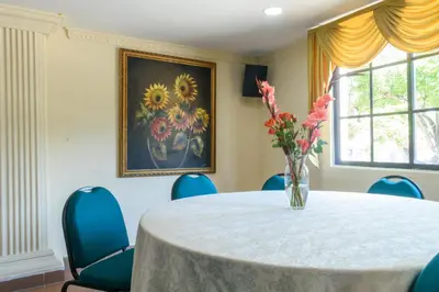 a round table with blue chairs and a vase of flowers at Hotel Caribe Plaza Barranquilla in Barranquilla