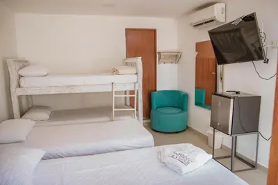 a room with two bunk beds and a flat screen tv at Hotel La Casona de Getsemani in Cartagena de Indias