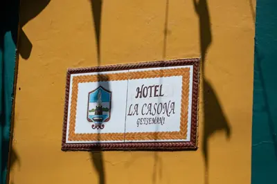 a sign on the side of a yellow wall at Hotel La Casona de Getsemani in Cartagena de Indias