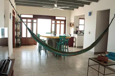 a hammock in a living room with a table and chairs at Frente al Mar in Santa Veronica