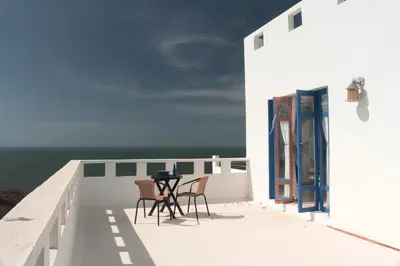 a balcony with chairs and a table on the side of a building at Frente al Mar in Santa Veronica