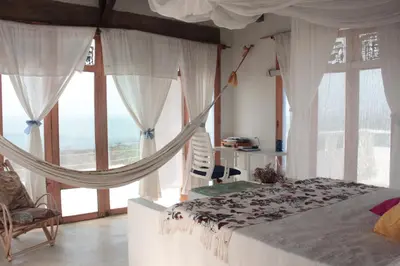 a bedroom with a hammock bed and large windows at Frente al Mar in Santa Veronica