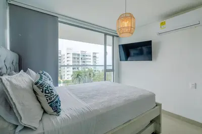 a bedroom with a bed and a large window at Escapada 5 estrellas frente al mar - sonest morros in Cartagena de Indias