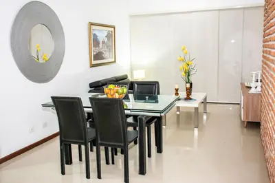 a dining room with a glass table and black chairs at Mirador del Laguito 1201 in Cartagena de Indias