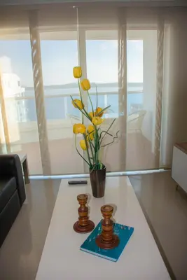 a living room with a vase with yellow flowers on a table at Mirador del Laguito 1201 in Cartagena de Indias