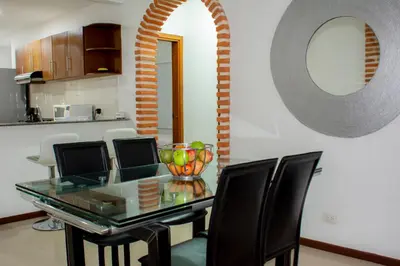 a dining room with a glass table and black chairs at Mirador del Laguito 1201 in Cartagena de Indias
