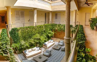 an indoor garden with white couches and plants at Hotel Casa Canabal by Faranda Boutique in Cartagena de Indias
