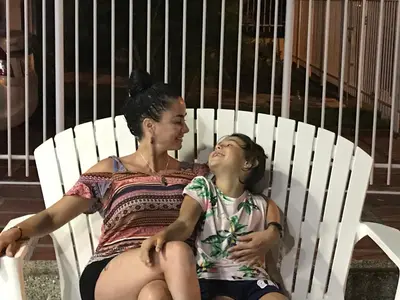 a woman and a girl sitting in a white chair at Costana - Hostal in Cartagena de Indias