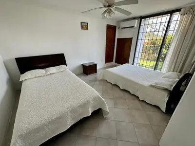 a bedroom with two beds and a ceiling fan at Casa Miramar in Santa Marta
