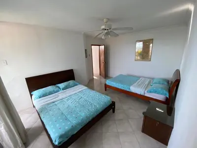 a bedroom with two beds and a ceiling fan at Casa Miramar in Santa Marta
