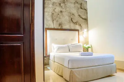 a bedroom with a bed with a painting on the wall at Hotel Virrey Cartagena in Cartagena de Indias