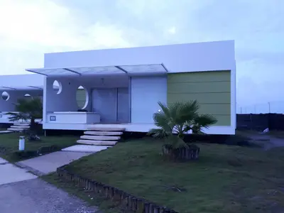 a house with a green door and a green garage at cabaña puerto velero in Puerto Caimán