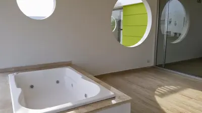 a white bathroom with a tub and a mirror at cabaña puerto velero in Puerto Caimán