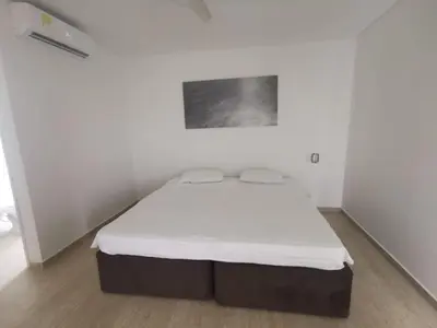 a bedroom with a bed in a white room at cabaña puerto velero in Puerto Caimán