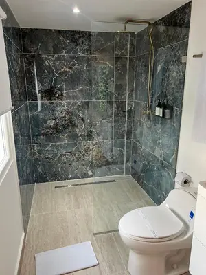 a bathroom with a toilet and a glass shower at Hotel Playa Club in Cartagena de Indias